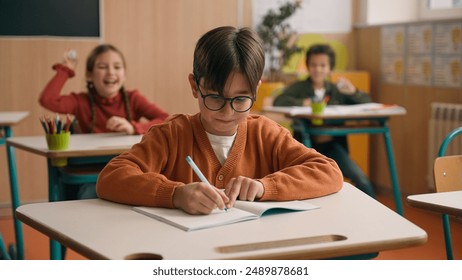 Caucasian little boy kid schoolboy nerd in glasses write task class lesson school education angry children cruel throw crumpled paper balls abuse abusing bullying classmates studying problem mock - Powered by Shutterstock