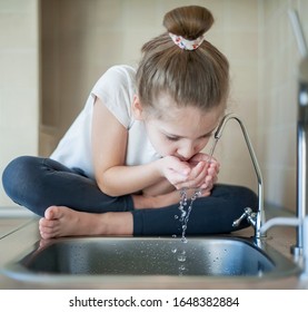 Caucasian Little Girl Drinking From Water Tap Or Faucet In Kitchen. Hands Open For Drinking Tap Water. Pouring Fresh Healthy Drink. Good Habit. Right Choice. Environment Concept. World Water Day
