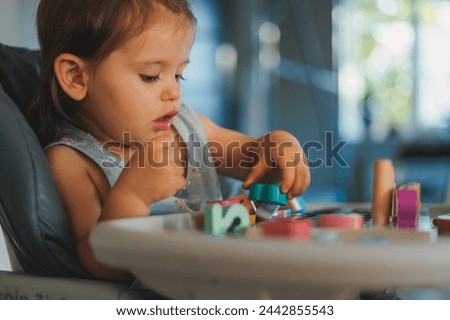 Similar – Baby Mädchen spielt mit Haarspangen, die auf dem Boden liegen.