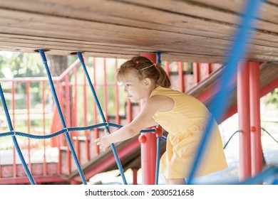 caucasian little girl playing with spider webs in summer. Children play and climb outdoors on a sunny summer day. - Powered by Shutterstock