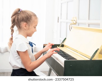 Caucasian little girl practice play piano in house. Cute kid learning to play piano. - Powered by Shutterstock