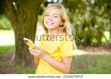 Similar – Teenager lächelnd, der sein Smartphone auf einem Basketballplatz aussieht.