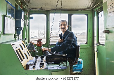 Caucasian Locomotive Engineer In The Cabin Driving The Train. Horizontal Shot