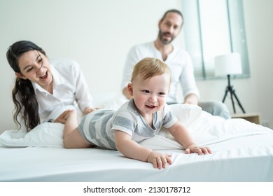 Caucasian Loving Parents Play With Baby Boy Child On Bed In Bedroom. Happy Family, Attractive Beautiful Young Couple Dad And Mom Dance With Cute Infant Toddler Son Enjoy Morning Activity After Wake Up