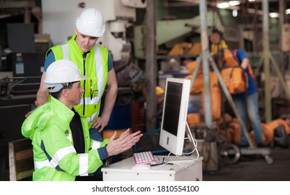Caucasian machine engineers and computer engineers are discussing. To install a computer program To be used to control machines to produce complete and quality products in industrial plants.