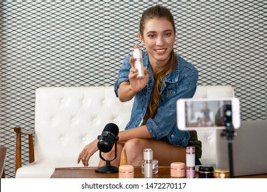 caucasian makeup artist youtuber influencer broadcasting demonstrating her cosmetic product live online