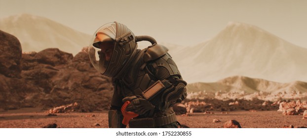 Caucasian male astronaunt in a space suit gathering materials on a planet surface, Mars colonization concept