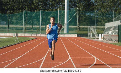 Caucasian male athlete in blue sportswear running alone along an athletic track on the stadium - Powered by Shutterstock