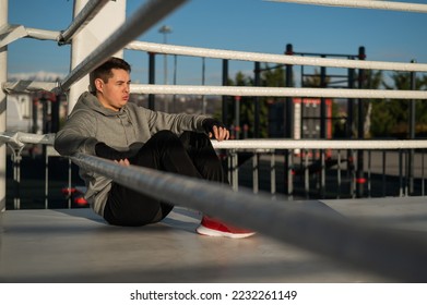 Caucasian male boxer resting in the ring outdoors.  - Powered by Shutterstock