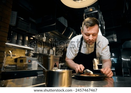 Image, Stock Photo Concentrated chef adding cream inside ceramic plate