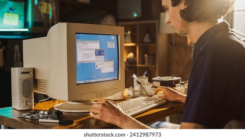 Caucasian Male College Student Using Old Desktop Computer In Nineties Retro Garage. Young Programmer Connecting World Wide Web Via Early Internet Software, Exploring Global Network. - Powered by Shutterstock - Get 15% off with code: PIKWIZARD15