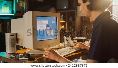 Caucasian Male College Student Using Old Desktop Computer In Nineties Retro Garage. Young Programmer Connecting World Wide Web Via Early Internet Software, Exploring Global Network.
