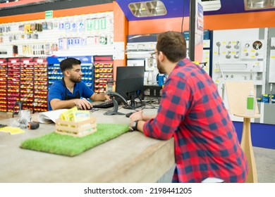 Caucasian Male Customer Looking To Buy Tools Or Paint And Asking A Question To The Hardware Store Worker 