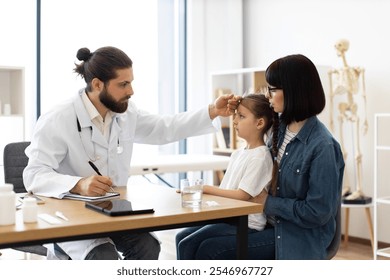 Caucasian male doctor measures temperature of young girl with concerned mother by her side in clinic. Doctor writes prescription while ensuring child's health and comfort. - Powered by Shutterstock