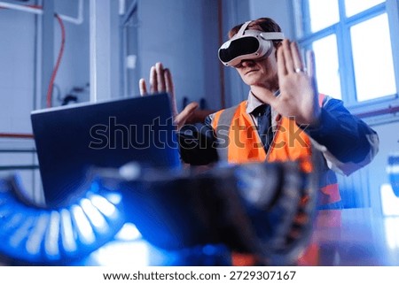 Caucasian male engineer using computer with vr in industrial setting with technology and innovation.