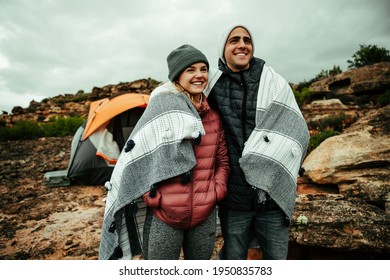 Caucasian Male And Female Couple Cuddling Under Warm Blanket Camping In Mountain