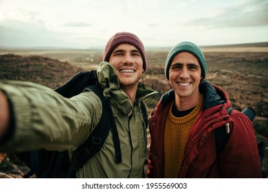 Caucasian male friend taking selfie with cellular device smiling while on outdoor hike