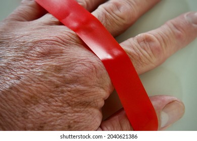 Caucasian Male Hand Covered In Red Tape