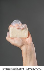 Caucasian Male Hand Holding Plain Bar Of Soap With Lather And Bubbles