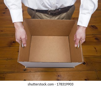 A Caucasian Male Holding An Empty Cardboard Box.