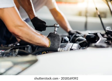 Caucasian male mechanic repairs car in garage. Car maintenance and auto service garage concept. Closeup hand and spanner. - Shutterstock ID 2018169392