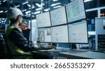 Caucasian Male Process Engineer Using Multi Monitor Workstation To Control Production Of Modern Electric Components on Autonomous Assembly Line With Robotic Arms. Man Adjusting Manufacturing Processes