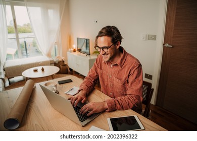 Caucasian Male Student Typing On Laptop Working At Home Desk Set Up 