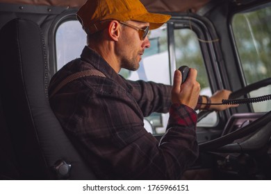 Caucasian Male Truck Driver Communicating On Two Way Radio Inside Of Vehicle Cab.  - Powered by Shutterstock