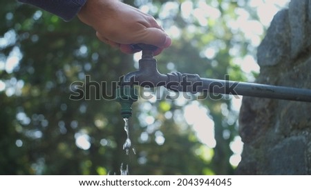 Caucasian Male Turning On and Turning Off Water Flowing from Public Faucet Fountain