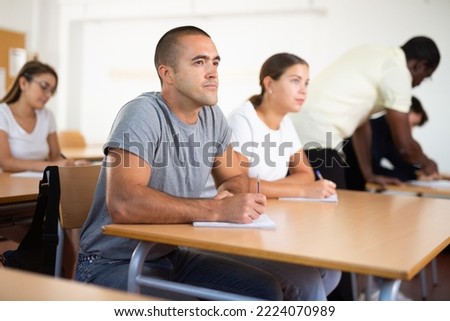 Caucasian man with adult students studying in university