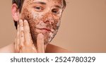 Caucasian man applying a facial scrub. Close-up of a man exfoliating with a facial scrub. Skincare routine for a man with facial scrub. Men