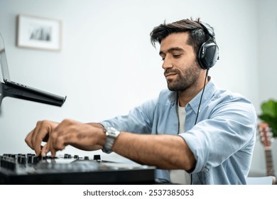 Caucasian man artist DJ mixing and scratching music mixer controller. Attractive male musician having fun mixing music on console touching buttons and playing electronic music in living room at home. - Powered by Shutterstock