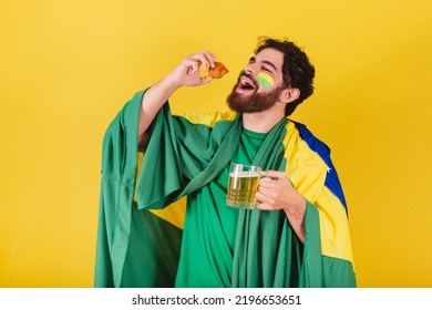 Caucasian Man With Beard, Brazilian, Soccer Fan From Brazil, Holding Glass Of Beer And A Chicken Drumstick, Typical Brazilian Food.