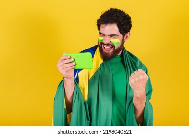 Caucasian Man With Beard, Brazilian, Soccer Fan From Brazil, Watching Soccer Match By Cellphone, Smartphone.