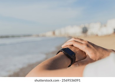 Caucasian man checking smartwatch while exercising on the beach