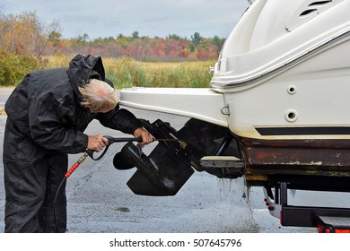 Caucasian man cleaning boat prop with pressure washer