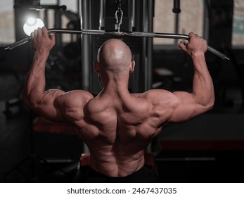 Caucasian man doing lat pull-downs on a machine. 