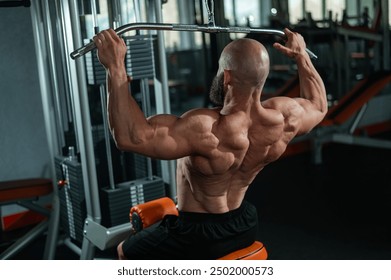 Caucasian man doing lat pull-downs on a machine. 