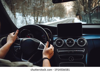 Caucasian Man Driving Car On The Empty Road, Winter And Snow Background

