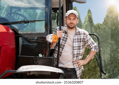 Caucasian man farmer stands next to agricultural tractor. - Powered by Shutterstock