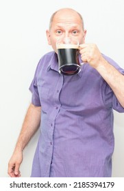 Caucasian Man Is Happy, Drinking Dark Beer From A Beer Mug.