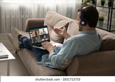 Caucasian man in headphone sit on sofa at home talk speak on video call with friends or colleagues. Young male employee in earphones have webcam conference or digital online meeting with coworkers. - Shutterstock ID 1831713733