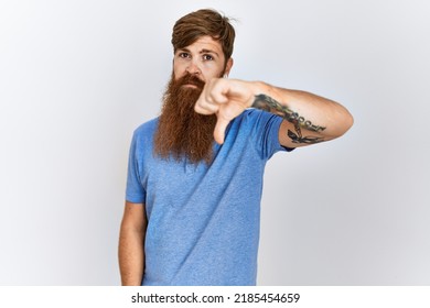 Caucasian Man With Long Bear Standing Over Isolated Background Looking Unhappy And Angry Showing Rejection And Negative With Thumbs Down Gesture. Bad Expression. 