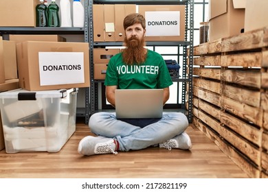 Caucasian Man With Long Beard Wearing Volunteer T Shirt Using Laptop Thinking Attitude And Sober Expression Looking Self Confident 