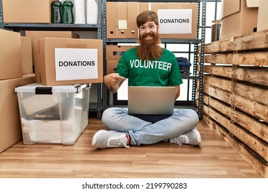 Caucasian Man With Long Beard Wearing Volunteer T Shirt Using Laptop Smiling Happy Pointing With Hand And Finger 