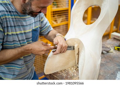 Caucasian Man Making A Wooden Sculpture With A Chisel