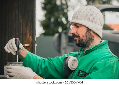 Caucasian Man Is Mixing Color And Preparing It To Spray It On The Vintage Car As A Restoration Project. Mixing Paint And Hardener Of An Automotive Paint Or Lacquer.