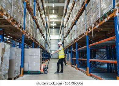 Caucasian Man Moving Boxes In A Huge Warehouse