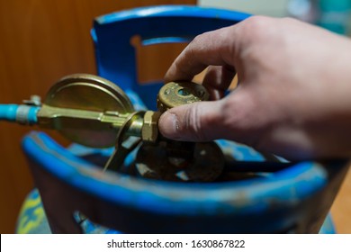 Caucasian Man Opening The Butan Gas Tank Valve For Home Use.