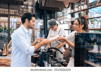 Caucasian man order hot coffee from woman waiter in coffee house. Young handsome entrepreneur female barista in apron give takeaway drink to customer in queue line on at urban restaurant cafe. - Powered by Shutterstock